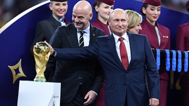 FIFA-Praesident Gianni Infantino (li, Schweiz) und Präsident Wladimir Putin (re, Russland) mit dem WM-Pokal bei der FIFA-Fußball-WM-2018. | Bild: picture alliance / Pressebildagentur ULMER