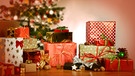 Wie ihr Geschenke richtig einpackt, lässt sich berechnen. Im Bild: verpackte Weihnachtsgeschenke unter einem Weihnachtsbaum. | Bild: picture-alliance/dpa