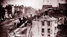 DIe Aufnahme vom "Boulevard du Temple" aus dem Jahr 1938 ist das erste Foto der Welt, das eine lebende Person zeigt. Louis Daguerre gilt nach Joseph Nièpce als Erfinder der kommerziellen Fotografie, mit seiner damailigen Erfindung: der Daguerreotypie. | Bild: picture-alliance/dpa/World History Archive