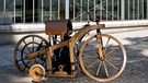 Gottlieb Daimler und der Reitwagen. Mit einer halben Pferdestärke und Stützrädern: Am 29. August 1885 meldete Gottlieb Daimler das erste Motorrad der Welt zum Patent an. | Bild: Daimler