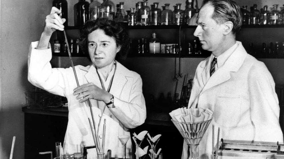 Die Biochemikerin Gerty Cori im Labormantel neben ihrem Ehemann Carl im Labor. Sie erhält 1947 als erste Frau den Nobelpreis für Medizin, obwohl sie lange zu seiner Helferin degradiert worden ist. Weitere Porträts von bedeutenden Frauen, die die Welt veränderten, gibt's auf dem Instagram-Kanal von FrauenGeschichte und bei ardalpha.de. | Bild: picture alliance / ASSOCIATED PRESS 