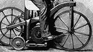 Wilhelm Maybach auf dem Reitwagen. Mit einer halben Pferdestärke und Stützrädern: Am 29. August 1885 meldete Gottlieb Daimler das erste Motorrad der Welt zum Patent an. | Bild: Daimler