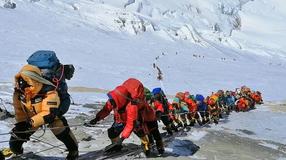 Bergsteiger stehen im Mai 2019 am Mount Everest, dem höchsten Berg der Welt, Schlange. Am 29. Mai 1953 schafften es Edmund Hillary und Tenzing Norgay auf den Gipfel des 8.848 Meter hohen Mount Everest. Ob sie wirklich die Ersten waren, denen die Erstbesteigung gelang? Zumindest waren sie die Ersten, die wieder lebendig vom höchsten Berg der Welt zurückkamen. | Bild: picture alliance / AP Photo