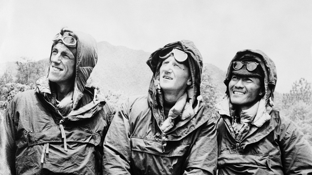 Edmund Hillary (l.), Expeditionsleiter John Hunt (Mitte) und Sherpa Tenzing Norgay (r.) am 26. Mai 1953. Am 29. Mai 1953 schafften es Edmund Hillary und Tenzing Norgay auf den Gipfel des 8.848 Meter hohen Mount Everest. Ob sie wirklich die Ersten waren, denen die Erstbesteigung gelang? Zumindest waren sie die Ersten, die wieder lebendig vom höchsten Berg der Welt zurückkamen. | Bild: picture-alliance/dpa
