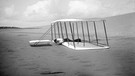 Wilbur Wright nach einer Landung 1901. Die Brüder Orville und Wilbur Wright verband der gemeinsame Traum vom Fliegen. Anfang des 20. Jahrhunderts versuchten sie ihn wahr zu machen - und es gelang! Wir erklären euch mehr über die beiden Pioniere des Motorflugs.  | Bild: picture alliance / Glasshouse Images | Circa Images