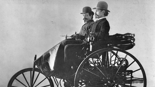 Carl Benz (vorn) auf seinem Patent-Motorwagen Typ III. Die ersten Automobile gab es um 1900. Heutige Automarken gehen auf Erfinder wie Carl Benz, Gottlieb Daimler, Rudolf Diesel, Henry Ford und Adam Opel zurück. | Bild: Daimler