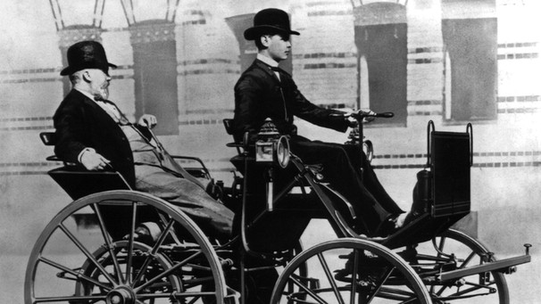 Gottlieb Daimler wird von seinem Sohn Adolf Daimler in einer "Motorkutsche" chauffiert | Bild: picture-alliance/dpa