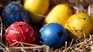 Nest mit ausgeblasenen Ostereiern. Verzierte, bunte Eier haben zu Ostern im Osternest Hochkonjunktur. | Bild: picture-alliance/dpa