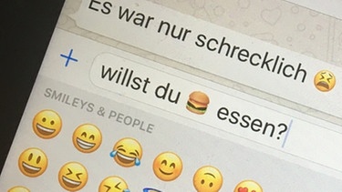 Jemand tippt auf dem Smartphone eine Whatsapp-Nachricht mit Emojis ein | Bild: picture-alliance/dpa/Christiane Oelrich