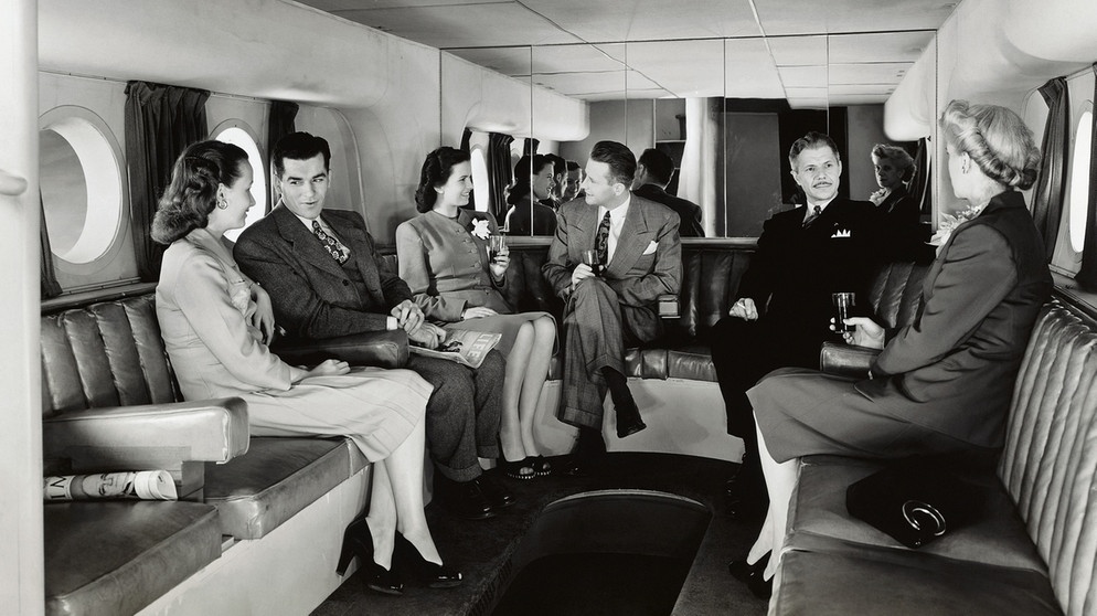 Erste-Klasse-Passagiere an der Bar einer Boing Stratocruiser im Jahr 1949. Seit 100 Jahren servieren Airlines ihren Passagieren Essen im Flugzeug. | Bild: picture alliance/Mary Evans Picture Library