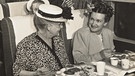 Frauen mit Hüten essen im Jahr 1947 in der Ersten Klasse einer American Airlines Dc-6, dahinter spricht eine Stewardess mti einem weiteren Passagier. Seit 100 Jahren servieren Airlines ihren Passagieren Essen im Flugzeug. | Bild: picture alliance/Mary Evans Picture Library