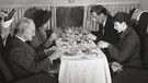 Im Jahr 1960 essen Passagiere an Bord einer Havilland Dh-106 Comet. Ein Steward serviert Wein. Seit 100 Jahren servieren Airlines ihren Passagieren Essen im Flugzeug. | Bild: picture alliance/Mary Evans Picture Library