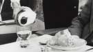 Eine Stewardess serviert einem Mann im Jahr 1970 Champagner in der Ersten Klasse.  Seit 100 Jahren servieren Airlines ihren Passagieren Essen im Flugzeug. | Bild: picture alliance/Mary Evans Picture Library