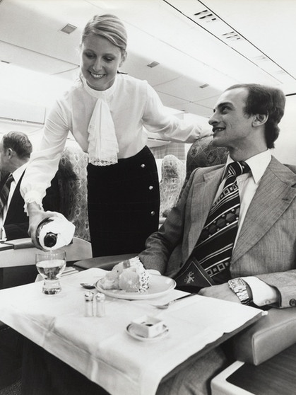 Eine Stewardess serviert einem Mann im Jahr 1970 Champagner in der Ersten Klasse.  Seit 100 Jahren servieren Airlines ihren Passagieren Essen im Flugzeug. | Bild: picture alliance/Mary Evans Picture Library