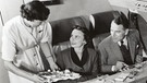 Eine Stewardess serviert im Jahr 1960  in der Erste Klasse Kabine den Passagieren Essen und Drinks. Seit 100 Jahre servieren Fluggesellschaften ihren Passagieren Essen. | Bild: picture alliance/Mary Evans Picture Library