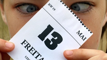Frau starrt auf einen Freitag, den 13., auf einem Kalenderblatt  | Bild: picture-alliance/dpa