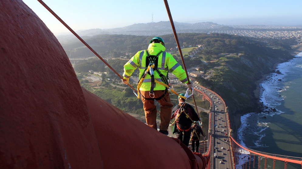 Anstreicher gehen auf dem Halteseil der Golden Gate Bridge | Bild: picture-alliance/dpa