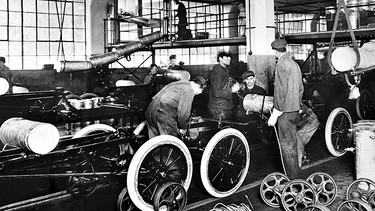 Fließband bei Ford 1913. Anfangs kann sich nur eine gutbetuchte Minderheit das Vergnügen leisten, mit einem Automobil über die Straßen zu rollen. Henry Ford ändert das 1908: Mit dem Fließband verwandelt er das Auto in ein Massenprodukt für jedermann. | Bild: Ford Motor Company