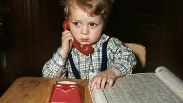 Kind mit Telefon und -buch | Bild: picture-alliance/dpa