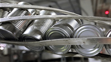 Konservendosen werden in einer Fabrik transportiert. | Bild: picture alliance / AP Photo