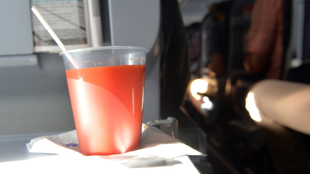 Ein Plastikbecher mit Tomatensaft steht auf dem Flug nach Berlin auf dem Klapptisch im Flugzeug. | Bild: dpa-Bildfunk/Maurizio Gambarini