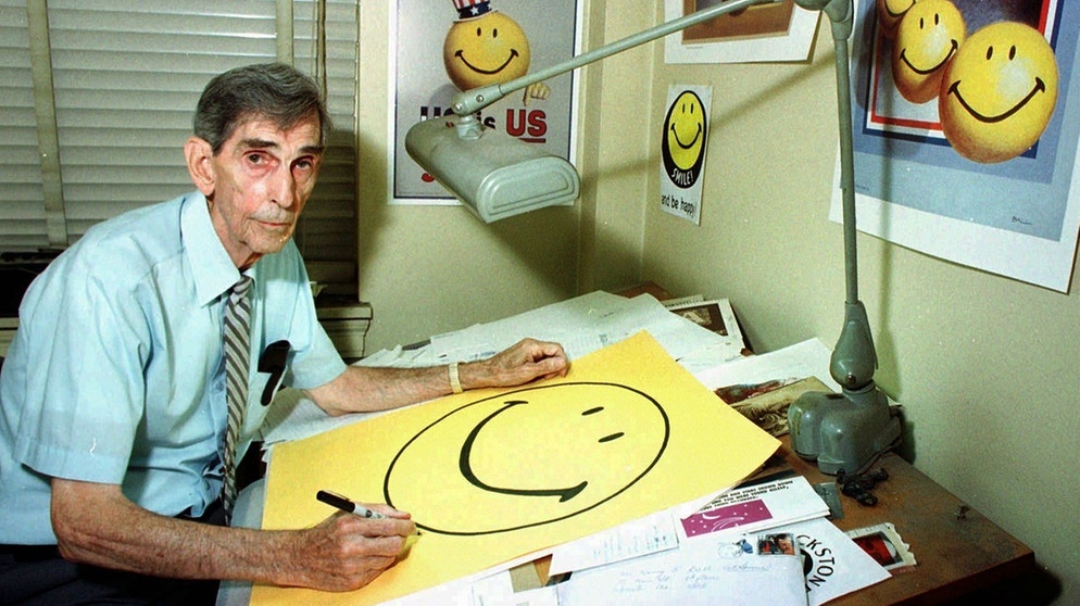 Der Werbegrafiker Harvey Ball mit seiner Schöpfung, dem Smiley. | Bild: picture-alliance/Associated Press/Paul Connors