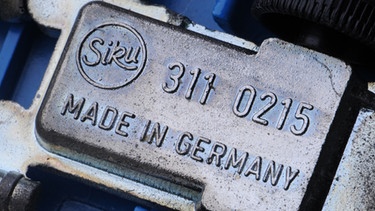 Unterseite Spielzeugauto "Made in Germany". Kennt ihr die Geschichte des Schriftzugs "Made in Germany"? Seit 1887 prangt er auf deutschen Produkten und sollte vor billigen Plagiaten warnen. Wir erklären euch, wie sich das Warnzeichen zum Qualitätssiegel entwickelt hat. | Bild: Armin Weigel dpa/lby