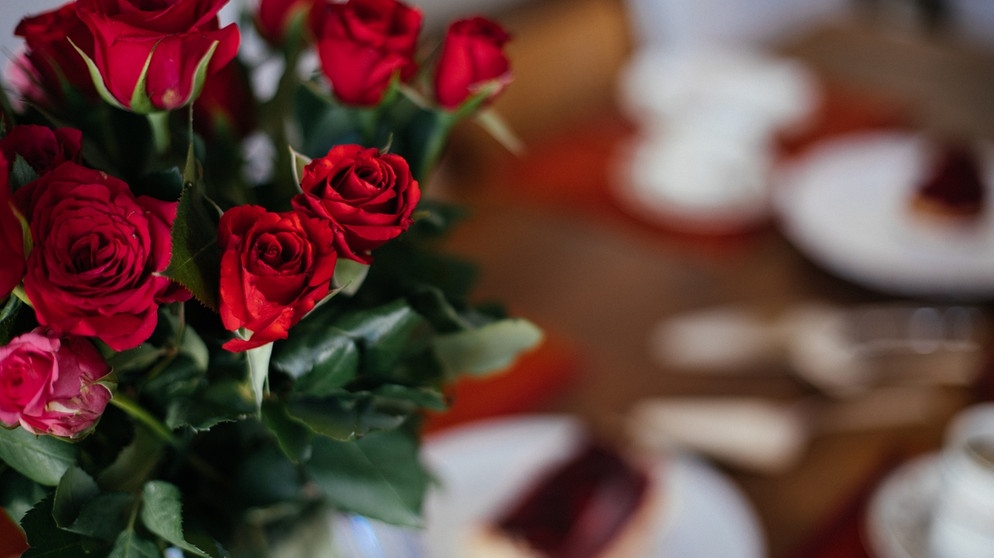 Rote Rosen stehen auf einem Tisch. Valentinstag - der Tag der Liebenden. Zeit, mal wieder dem Partner oder der Partnerin seine Liebe zu zeigen. Wie wird der Valentinstag in anderen Ländern gefeiert?  | Bild: BR/Julia Müller