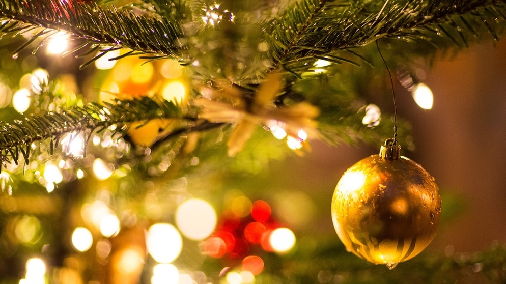 Eine goldene Kugel hängt an einem Weihnachtsbaum | Bild: dpa-Bildfunk/Friso Gentsch
