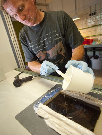 Geschieht auch in der Grube Messel: Ein Präperator befüllt eine Seite eines freigelegten Fossils mit Kunstharz | Bild: picture-alliance/dpa
