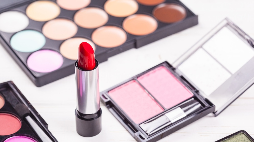 Ein Lippenstift liegt neben Make-up und Lidschatten. Auch in Kosmetikartikeln kann Aluminium enthalten sein.  | Bild: colourbox.com
