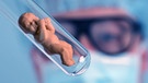 Symbolbild genverändertes Baby: Babypüppchen in einem Reagenzglas, Mediziner im Hintergund, | Bild: picture alliance / blickwinkel