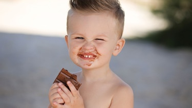 Kind beisst in Schokolade | Bild: colourbox.com