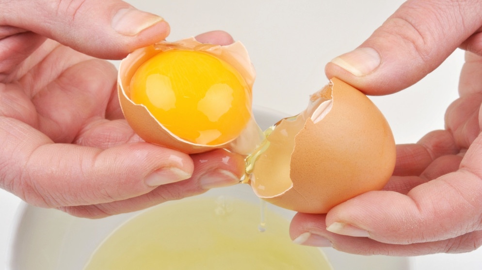 Hände halten aufgeschlagenes Ei | Bild: colourbox.com