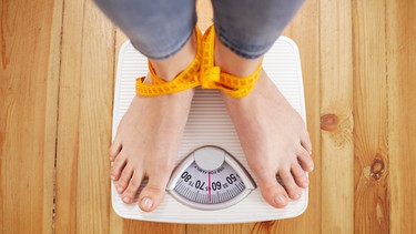 Füße stehen auf einer Waage. Durch Diäten wollen Menschen schlanker und schöner werden. Kurz: Sie wollen sich wohler fühlen in ihrer Haut. Aber wie sinnvoll sind Diäten wirklich und welche unerwünschten Folgen können sie haben? | Bild: colourbox.com