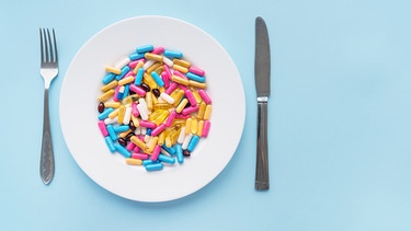 Vitaminkapseln auf Teller. Die Firma "More Nutrition" gehört zu den bekanntesten Anbietern von Nahrungsergänzungsmitteln. Wie sinnvoll und wirksam sind Vitaminkapseln und Co wirklich? Die Quarks Science Cops haben für euch recherchiert. | Bild: colourbox.com