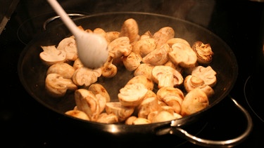 Champignons in einer Pfanne: Pilze müssen immer gut erhitzt werden. Fast alle Speisepilze sind roh giftig. | Bild: picture-alliance/dpa
