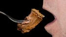 Detailaufnahme: Ein Mann führt auf einer Gabel ein Stück Roastbeef zu seinem Mund. | Bild: colourbox.com