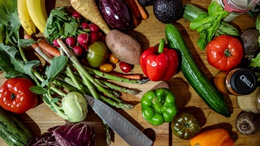 Eine Ansammlung an Gemüse und ein Messer liegen auf einem Schneidebrett auf einem Tisch. Ist frisches Gemüse gesünder als tiefgekühltes? | Bild: dpa-Bildfunk/Fabian Sommer