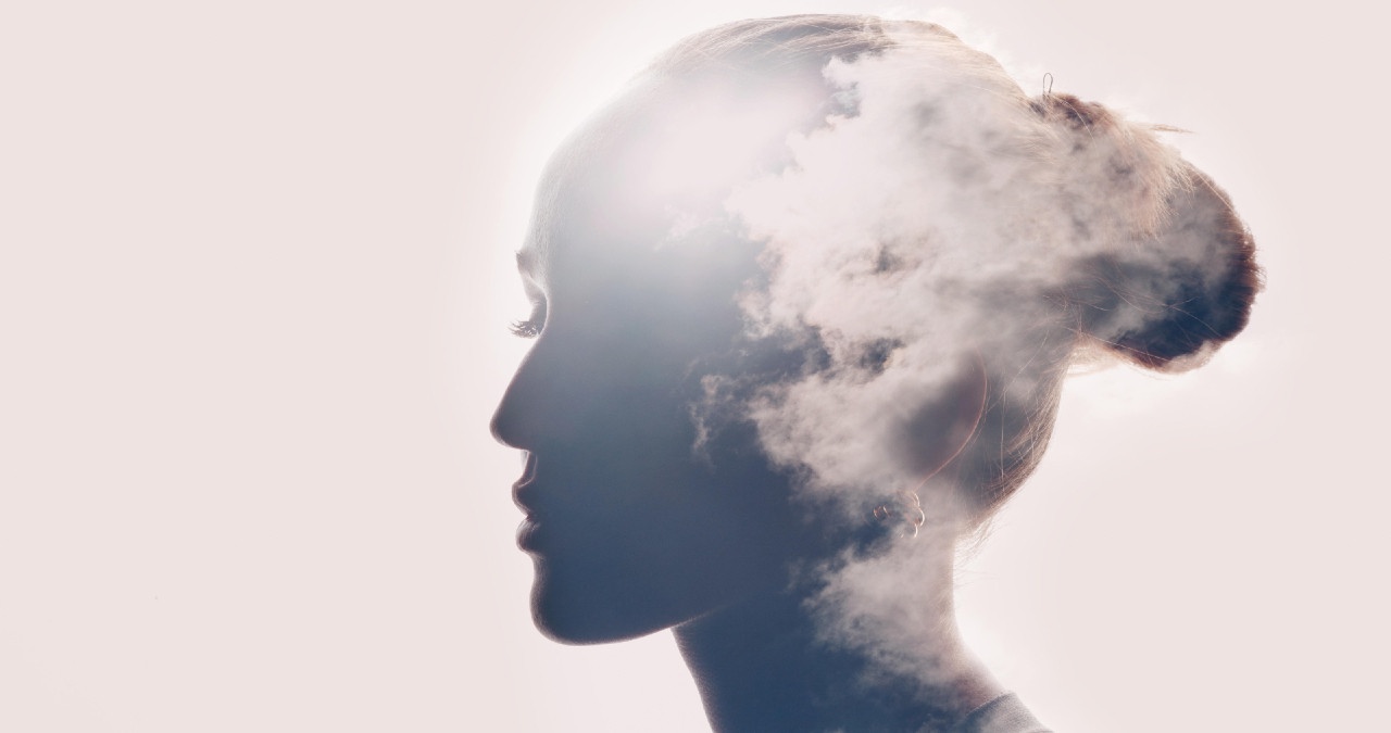 Wolken und Sonne spiegeln sich auf dem Kopf einer Frau. Unser Gedächtnis unterscheidet zwischen traumatischen und negativen Erinnerungen? | Bild: picture-alliance/dpa/Zoonar | Max