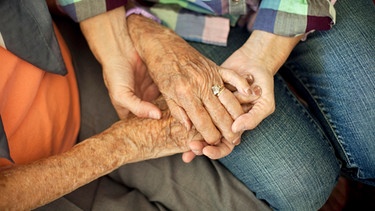 Alte und junge Hände halten sich.  | Bild: picture-alliance/dpa/Bildagentur-online/Blend Images