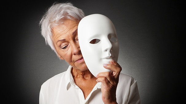 Ältere Frau hält Maske in der Hand. Der Alterungsprozess zeigt sich durch Falten und graue Haare, doch ist man deshalb schon alt?  | Bild: picture-alliance/dpa/Zoonar/Axel Bueckert