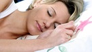 Schlafende Frau in Seitenlage im Bett: In der Nacht betätigt sich das Gehirn als Müllabfuhr. | Bild: picture alliance / blickwinkel/M. Baumann