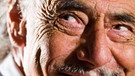 Haut: Verschmitzte Falten im Gesicht eines älteren Herren mit einem Grinsen | Bild: picture alliance/ Golden Pixels LLC