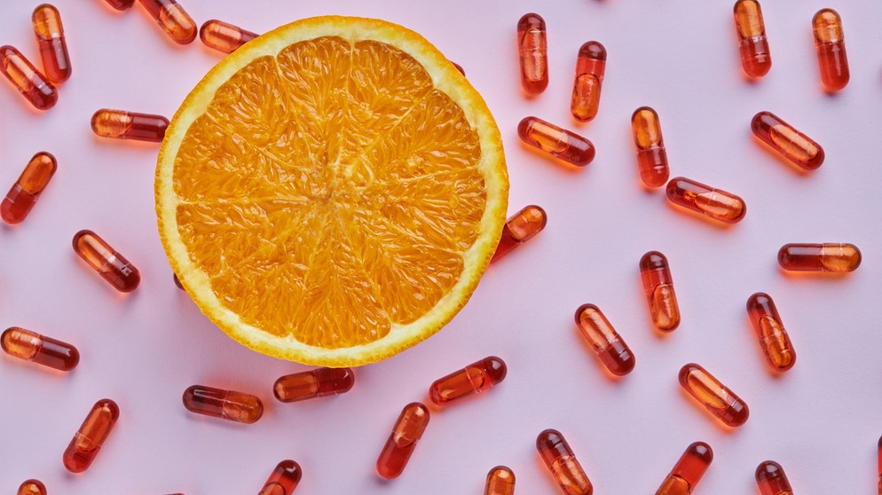Eine halbe Orange liegt neben bräunlichen Kapseln auf einem Tisch. Das Immunsystem ist ein Schutzschild, das den Körper vor Krankheitserregern schützt. Ausreichend Schlaf und eine vitaminreiche Ernährung helfen die Körperabwehr zu stärken.  | Bild: picture alliance / Shotshop | Addictive Stock