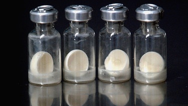 Gläschen mit weißer Tablette - einem Pockenimpfstoff. Obwohl Pocken als ausgerottet gelten, wird der Impfstoff für den Notfall heute noch millionenfach in Deutschland gelagert. | Bild: picture-alliance/dpa