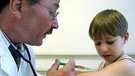 Impfung beim Arzt: Arzt gibt Jungen Spritze in den Oberarm | Bild: picture-alliance/dpa