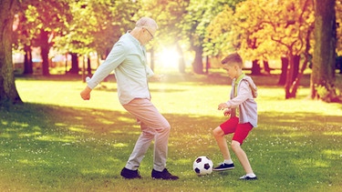 Ein Junge und ein älterer Mann spielen Fußball. Können wir Menschen bald schon viel länger und gesünder leben? Wir erklären euch aussichtsreiche wissenschaftlichen Entdeckungen der Alternsforschung für ein gesundes Altern und ein längeres Leben. | Bild: colourbox.com/Syda Productions