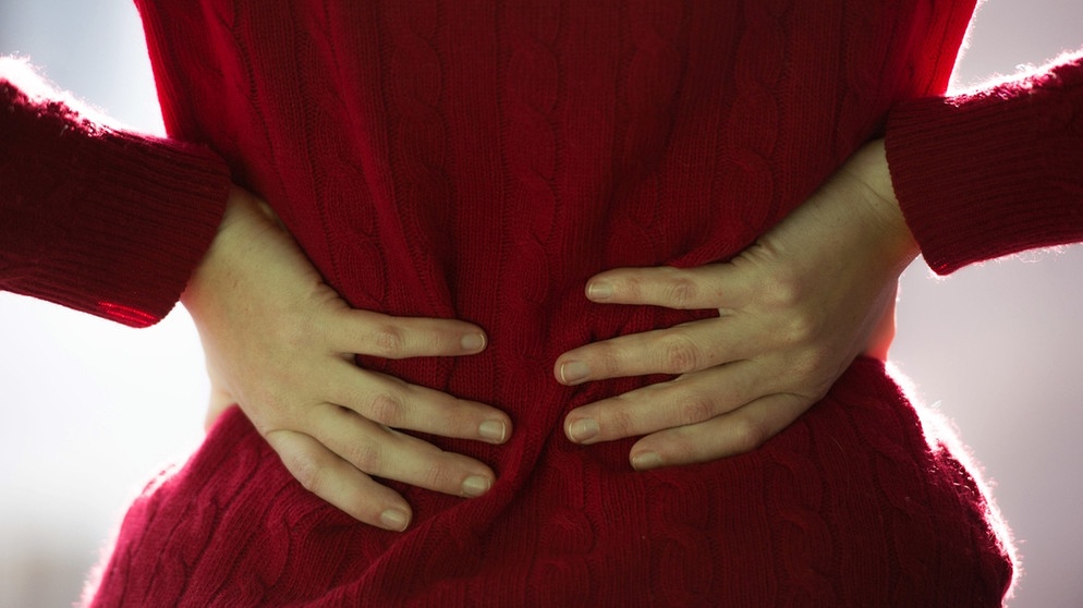Eine Frau hält sich den Rücken. Wird der Ischias-Nerv eingeklemmt oder gereizt, kommt es zu starken Rückenschmerzen, der Ischialgie. | Bild: dpa-Bildfunk/Lino Mirgeler