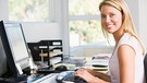 Eine junge Frau sitzt am Schreibtisch. Langes Sitzen kann auf Dauer zu Rückenschmerzen führen. Wie Sie es Ihrem Rücken angenehmer machen. | Bild: colourbox.com